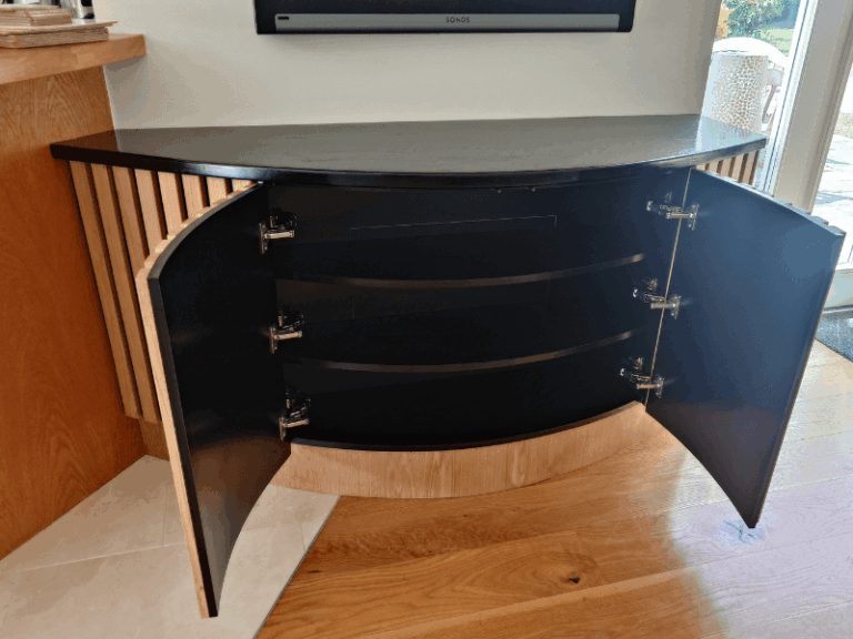 Internal storage shelves inside curved bespoke TV unit
