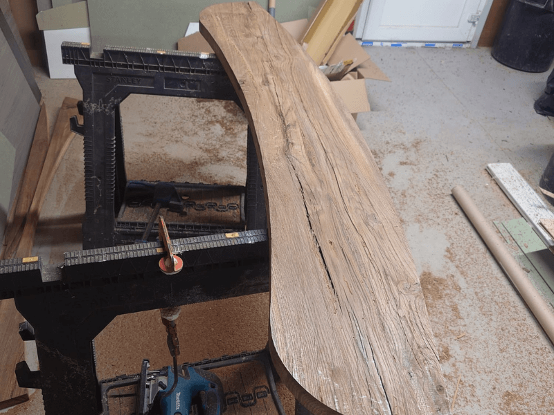 Bespoke curved reclaimed oak shelf in joinery workshop